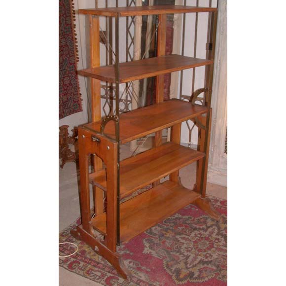 A late 19th century display shelf table in oak with an iron frame, X back stretchers and an adjustable mechanism, standing on castors. Table H82cm, L155cm, D83cm. Stamped.