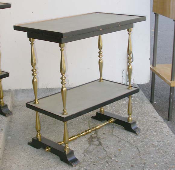 A pair of two tier end tables with tuned bronze columns and stretcher frame, ebony stained wood footing and framed leather sunken plateau tops.