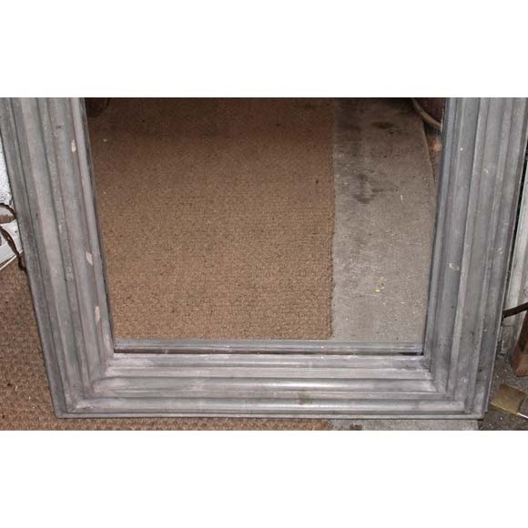 A rectangular grooved zinc framed mirror with a wooden back.