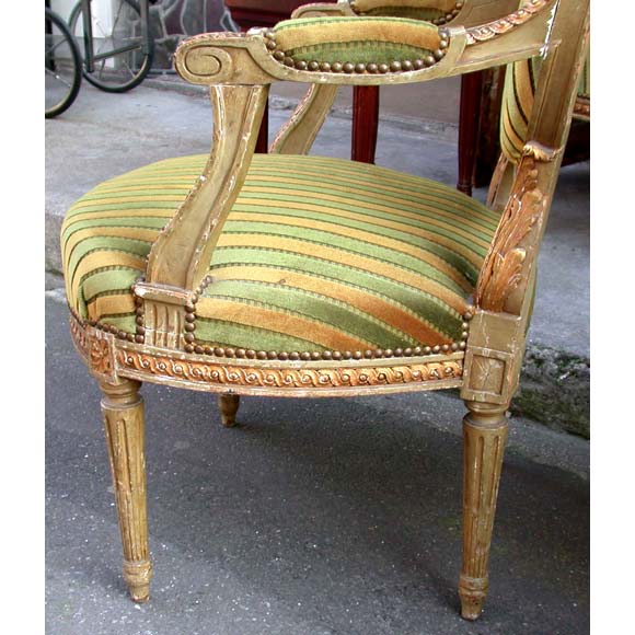 Pair of gilt and green patina carved oval back Louis XVI style fauteuils upholstered with a striped green and gold velvet.