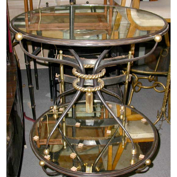 A pair of gueridons or end tables by Merceris with patina and partial gilt patina wrought iron frames, four legs with a central gilt rope and gilt ball sabots with round cloudy oxidized mirror plateaus.