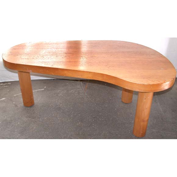 A coffee table with three round thick column legs and a thick 
