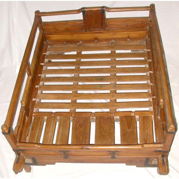 A late 19th century Southern Korea sedan chair in elm wood with iron hinges, slat seat, rod back and sides, holes on the side for carrying bars (not available) and lotus flower carved back.