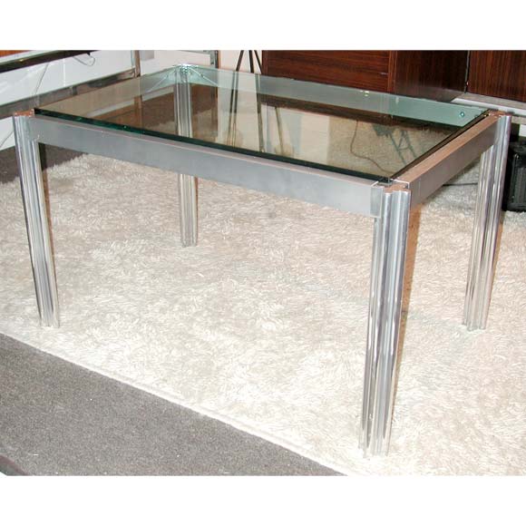 A coffee table by Cicimino with heavy chrome legs and an aluminum frame with puzzle connected legs and a thick glass plateau.