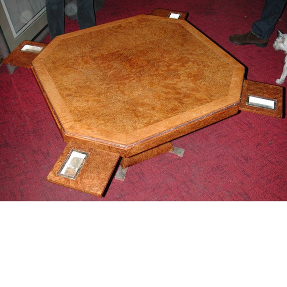 A convertible pillared foot coffee table raising to a game table, thought to be 1930's Dominique in burr Toya wood and solid  bronze silver plated  frame, decoration with small game chip cups on built in sliding  trays and a removable top which can