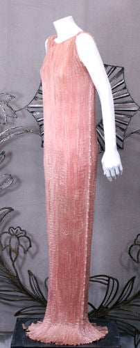 Mariano Fortuny shell pink pleated silk Delphos gown circa 1930. Striated white murano glass bead and silk cord trimmed down side seams and armhole. Silk belt stencilled in silver foliate patterns.<br />
<br />
As renown specialists in Fortuny,