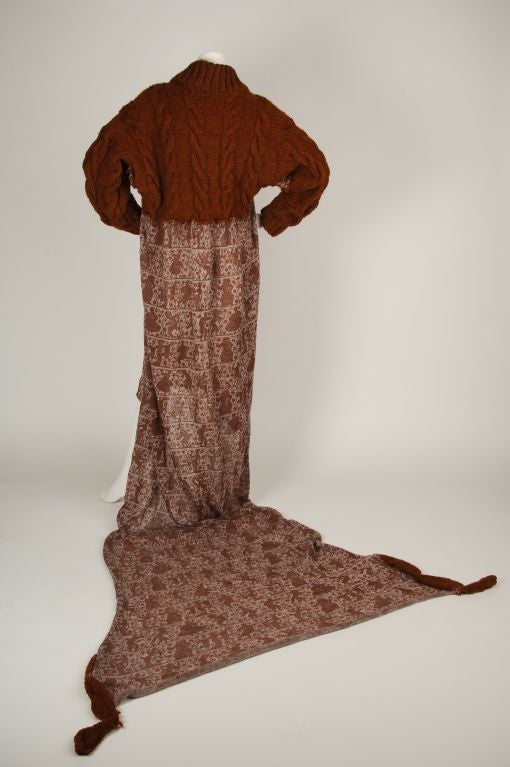 Sweater Dress. The top portion is an ochre chunky cable knit and the bottom is a narrative weave in a darker ochre on a lavender gray base. The seams on the dress are raw. Long sleeved with a long train.<br />
<br />
ABOUT THE DESIGNER- VIVIENNE