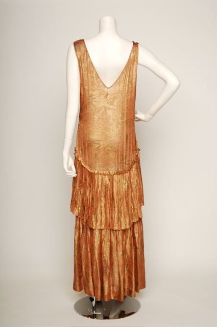 1920s – Gown, salmon pink with gold lame. Leaf design with drop waist, double pleated skirt. Ruching at middle bodice and sides. V-neck, sleeveless.