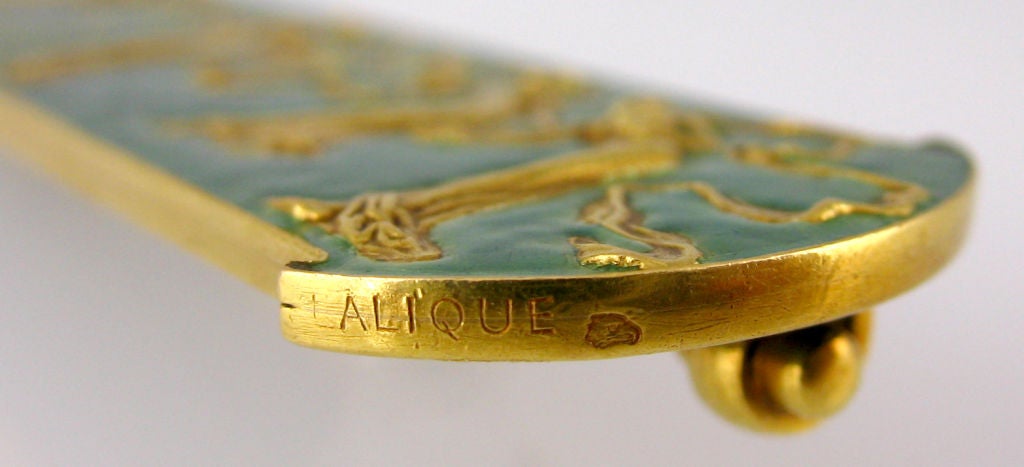 René Lalique brooch made of 18 karat yellow gold and blue enamel.  Art nouveau period, ladies with ribbon motif.