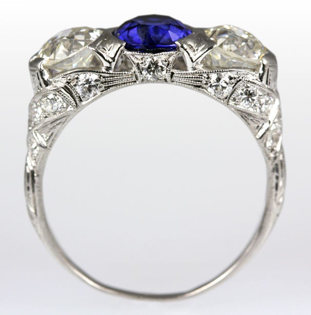 This platinum Edwardian 3 stone ring dances with life.  Two Old European cut diamonds, Old European accent diamonds and a lively sapphire truly make this ring a sight to behold.<br />
2.60ct total diamond weight, 1.40ct total sapphire weight.