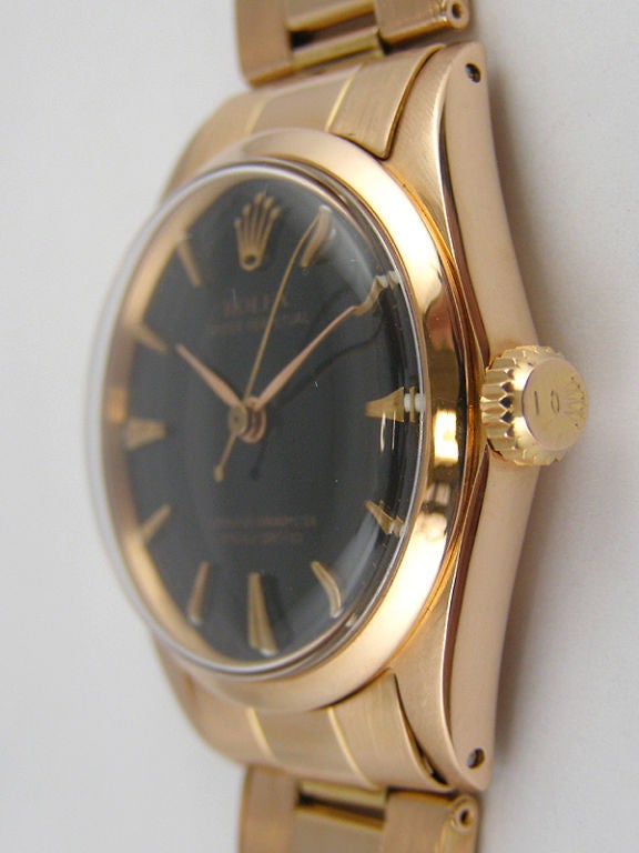 Rolex 18K PG 31mm midsize model ref 6551 circa 1958. Smooth bezel, glossy black dial with pink gold applied tapered and faceted indexes and pointy dauphine hands. Self winding movement with sweep seconds. With 18K PG Oyster bracelet. A beautiful