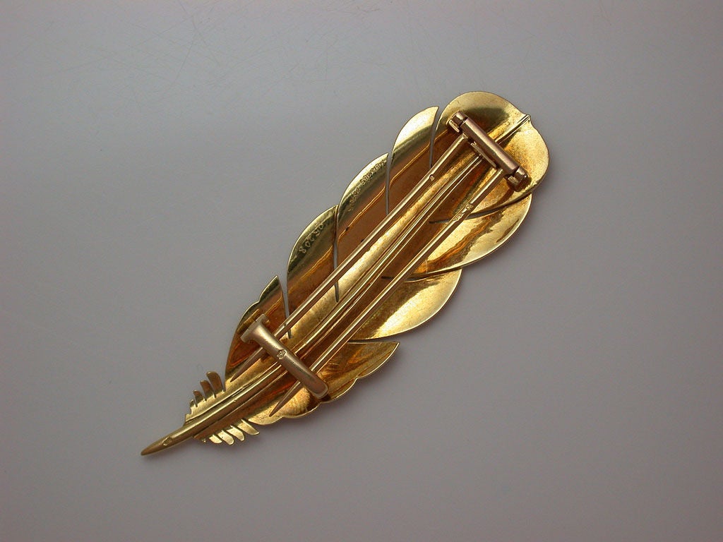 Realistically designed as a feather, signed Hermès Paris, #25208, with French maker's mark, French assay mark for 18kt gold, and safety catch, circa 1955.
