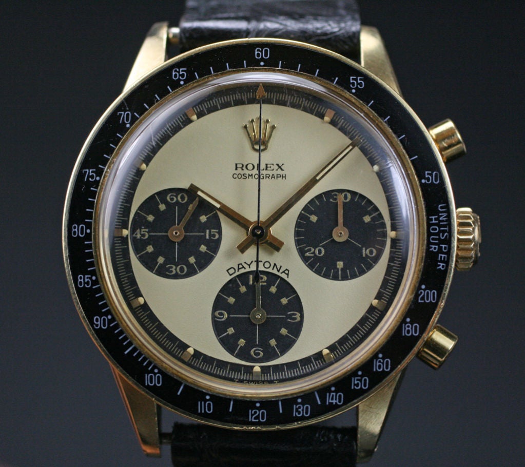 This Ref.6241 in 14K yellow gold is a great collector's piece. It is a beauty in 14K yellow gold, with the two tone cream and black Paul Newman dial and black tachymeter bezel. The watch comes on a leather band and has a gold Rolex Buckle. Circa 1969