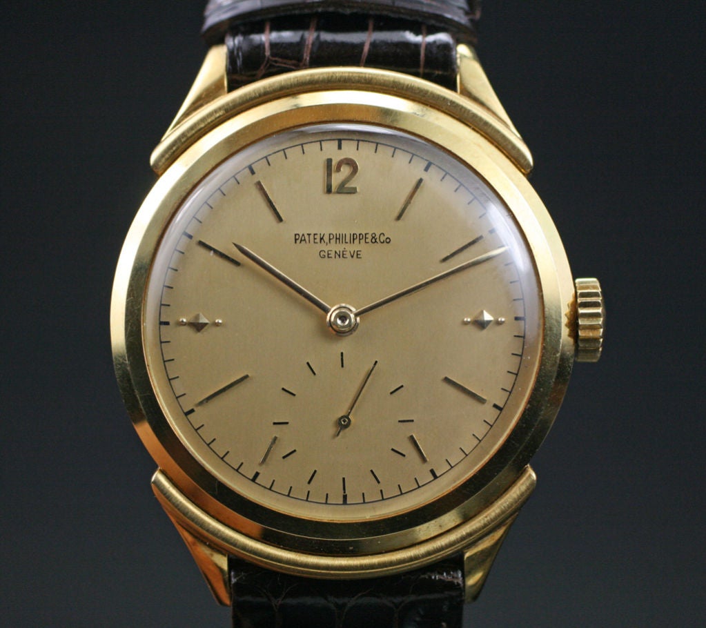 This is an extremely rare Patek Philippe from the 1950's. It is a ref.2426 with a manual wind movement. This watch is in new old stock condition. The case is very ornate with hooded lugs, and a gold dial. We have not seen this model in many years. 