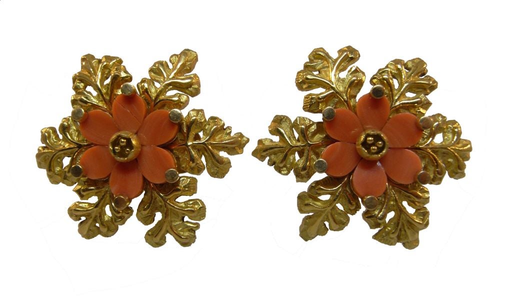 A brooch (2.5 inches wide) and pair of earclips (1 inch wide) in 18kt gold designed as a six petalled coral flower with a five-stamened center to a six leaved lost-wax cast gold base.  Signed 'Bvlgari', marked '18kt'.