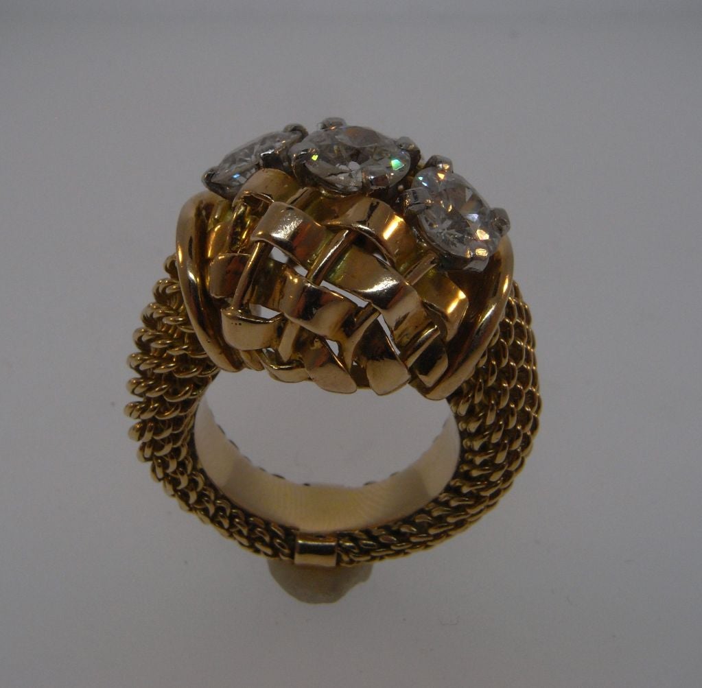 Woven gold ring set with three diamonds weighing a total of approximately 2.5 carats to a mount of interwoven gold strands and wires, to a basket weave gold shank.  Marked 'Boucheron' and 'Paris', with French marks for gold.  Ring size 10.
