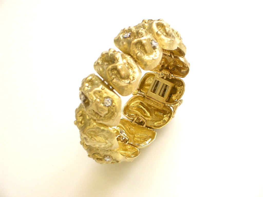 An unusual diamond and 18k yellow gold bracelet by David Webb.The nugget style links form a rigid circular bracelet-almost like a cuff. The 1.00ct.diamond enhanced bracelet is reminiscent of the surface of the moon. A likely inspiration for this