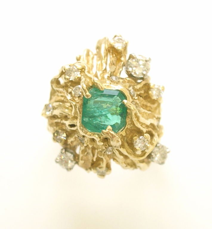 A pretty 14k yellow gold emerald and diamond ring by Nathan Cabot.The square cut emerald of medium color and inclusion weighing approximately one carat. It is a handsome stone- with a vibrant life. The diamonds range in size from approximately.20ct