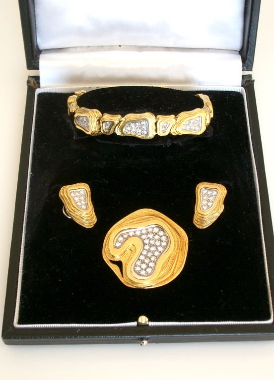 An interesting and versatile set of diamond and gold Jewelry. The set consisting of a pendant/brooch, earclips and bracelet. The freeform sculptural demi-parure reminiscent of a mesa can be mixed or matched to suite the wearer. Designed in 1975,