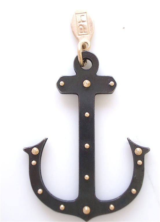 A charming pendant by Philip Crangi. The 14k yellow gold and oxidized steel anchor measuring 1 1/4