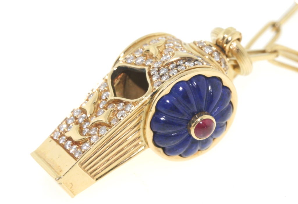 18k gold functioning whistle pendant with carved lapis sided embellished with cabochon rubies and a beautiful design in diamonds along the spine of the whistle,1.5