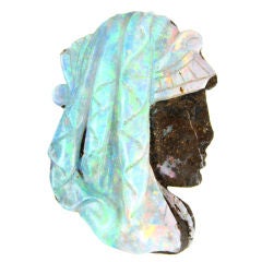 An antique carved opal and gold pin
