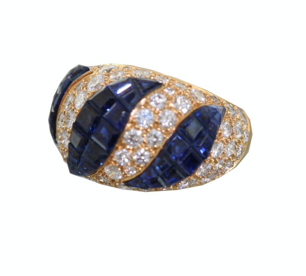 Van Cleef & Arpels  Serti Mysterieux ring mounted as three alternating waves of invisibly set sapphires and pave diamondsmounted in yellow gold. An elegant and contemporary update on a Van Cleef classic . Fully marked , signed and numbered M37921. 