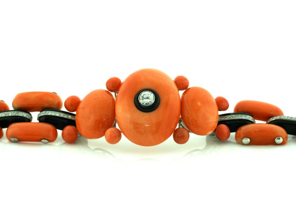 Platinum, Coral and Onyx art deco bracelet with .32ct round Diamond center stone and .72cttw diamond accents.