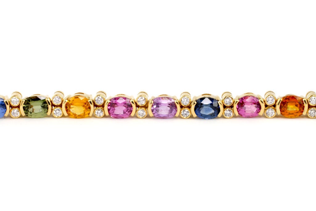 This beautifully-made, flexible 18kt Gold, Diamond and Multi-color Sapphire Bracelet shows off the spectacular color range of sapphires.  Classic and cheerful, both fun and elegant, this piece is perfect for any occasion.  Contains 23 Oval Shape