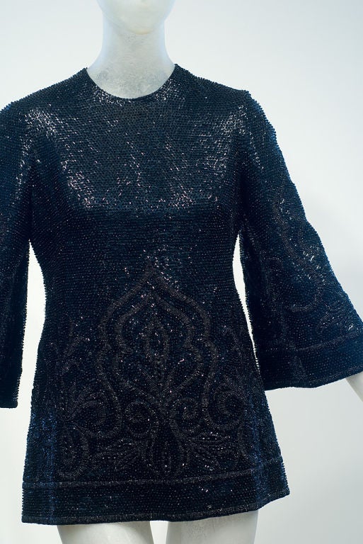 This 1960s English tunic invokes images of Yves Saint Laurent’s Morocco with its Moorish inspired bead and sequin all over black on black embroidery.  Like a rare bird in a garden filled with the scent of roses floating in a fountain you will look