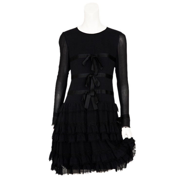 Black silk georgette cocktail dress 1920's inspired shape.<br />
Dress has tiered ruffled skirt with lace detail and black satin ribbon on bodice and cuff. Sleeves are sheer georgette.<br />
 May 2004.