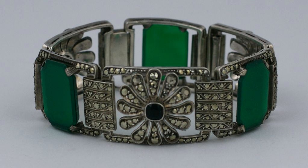 Attraktives Armband aus Markasit auf Sterling aus der Zeit des Art déco um 1930. Achteckige, geschliffene Plaketten aus grünem Onyx sind mit floralen Markasit-Motiven und schwarzen Onyx-Zentren versehen.<br />
Ausgezeichneter Zustand.<br />
7,25