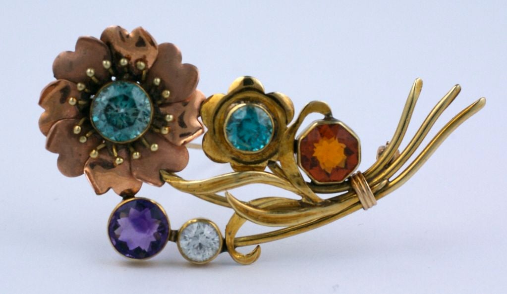 This is an unusual arts and crafts/ retro gold spray pin. It is marked 14k and set with beautiful gemstones such as amythest, citrine, blue zircon, and white sapphire. It is in excellent condition with the flowerhead in pink gold and the body done
