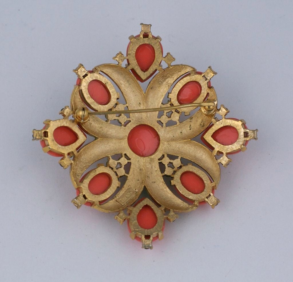 Trifari crest brooch in faux coral and green enamel with faux emerald stones accents evocative of the Webb pieces fof the period.<br />
Excellent condition<br />
2.5