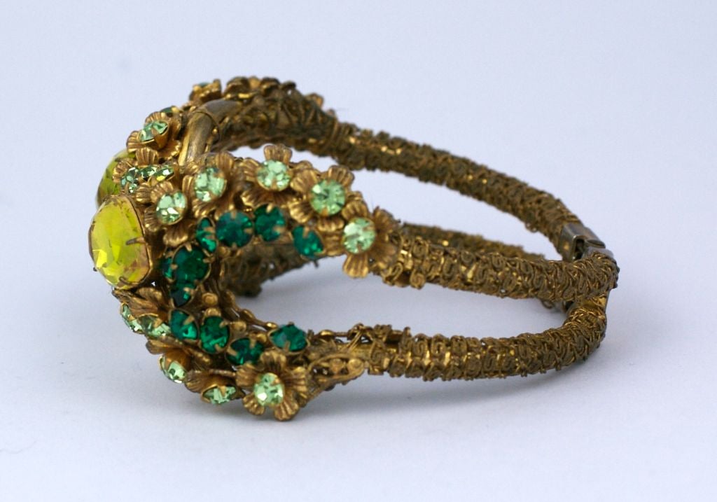 Miriam Haskell signed Chartreuse, peridot and emerald paste spring action cuff. Chainette wrapped arms on bracelet. Some wear on gilding.  <br />
Small size: 2