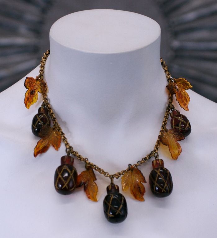 Charming Acorn and leaf charm necklace. Root beer colored carved bakelite acorns with celluloid leaves. Original brass chain.<br />
Acorns: 1.25