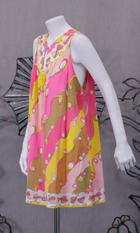 Emilio Pucci for Formfit Rogers baby doll dress in nylon jersey. Print of ribbons and bows in pink, yellow,tan, and ochre on white ground.<br />
Can be worn with button closure in front or back.<br />
Vintage size: 38