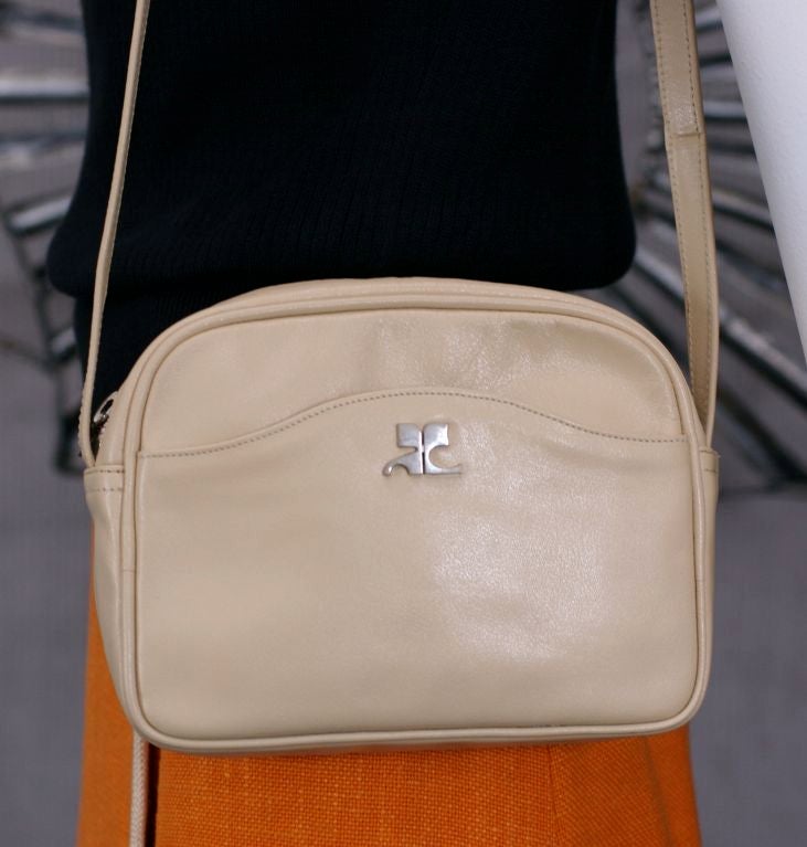 Charming Courreges logo shoulder bag in beige leather circa 1970's. One outer pocket and one interior pocket. Practical size with faille lining great condition. 
7.5