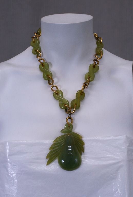 Unusual carved bakelite necklace from the 1940s. Hand carved pearlized jade bakelite links are interdispersed with gilt chain. A large carved pear pendant is suspended below.<br />
Very good conidtion.<br />
18