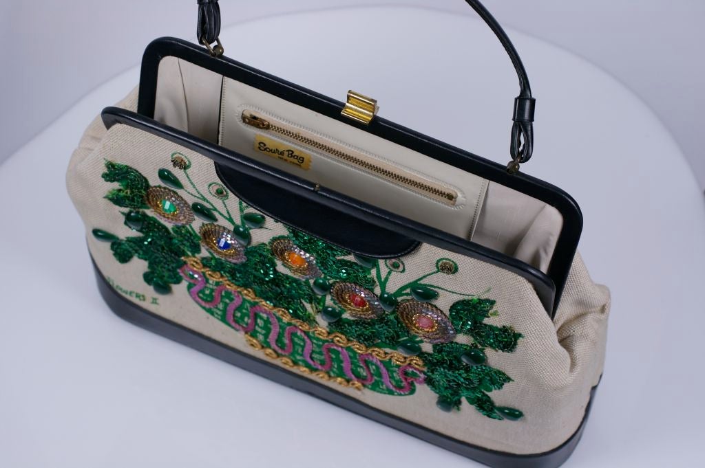 Amusing Soure NY bag from the 1960's decorated with a flower basket motif. Sequinned flowers, leaves with fantasy stones.  Black vinyl trim, lined in tan  plastic.<br />
Back of bag is undecorated tan cotton canvas.      <br />
16