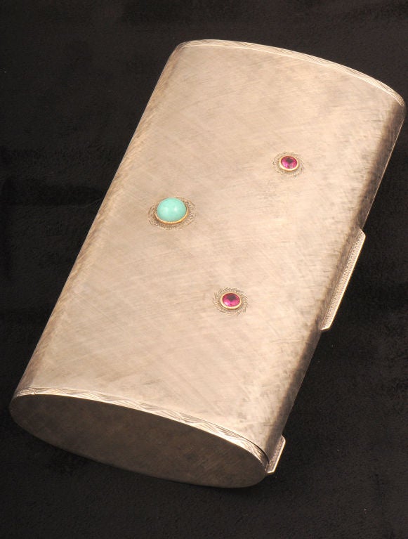 A sterling silver evening purse with cabochon rubies and turquoise set in gold bezels, the fitted interior has a mirror, comb, and 3 compartments.