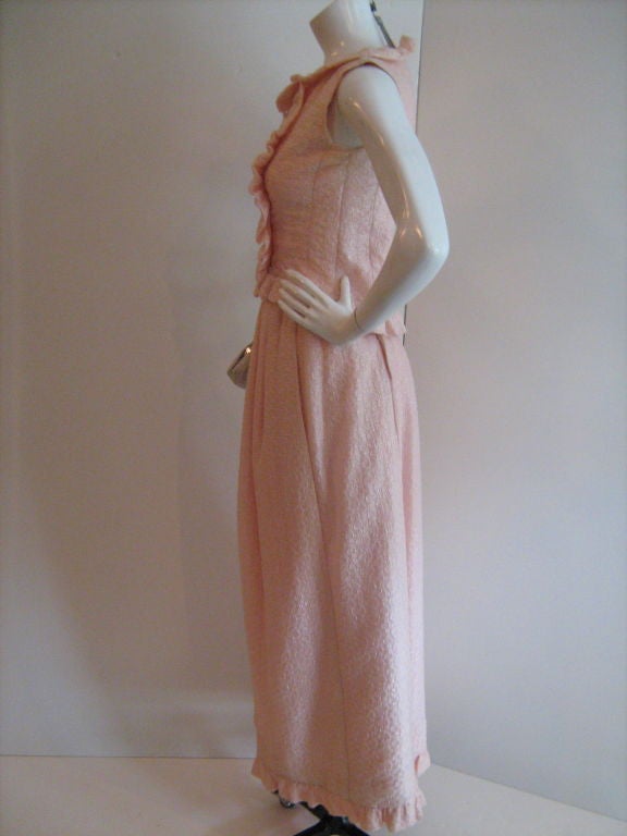 This is a rear couture baby pink Courreges, double-breasted evening ensemble with sleeveless top and long ruffled skirt is a rare piece of fashion history. The buttons are made of small glass beads.

Sleeveless Top Measurements: Shoulder to