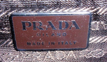 This is a dark brown alligator embossed handbag by Prada, from 1990. The handbag has a black velvet trim, two handles that are 5