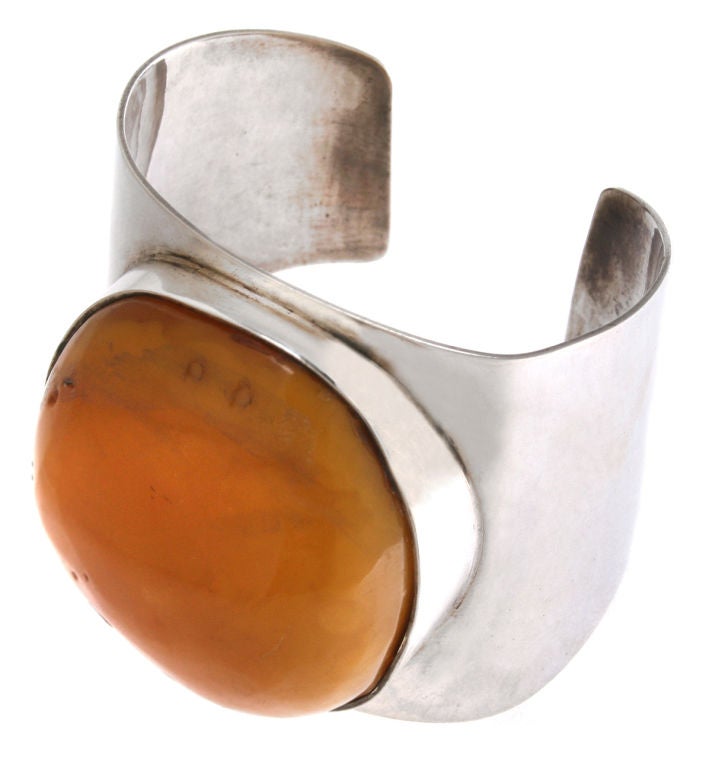 This is a fabulous bracelet.  It looks great on and fits a medium wrist. Measuring 7 inches + for the inner diameter and  2.5 inches wide, the amber cabachon protrudes .75 of an inch from the bracelet band.