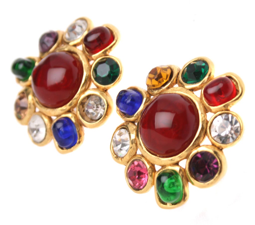 This pair of earrings complement the brooch we have listed. A central glass cabochon is surrounded by smaller colored cabochons as well as faceted glass.