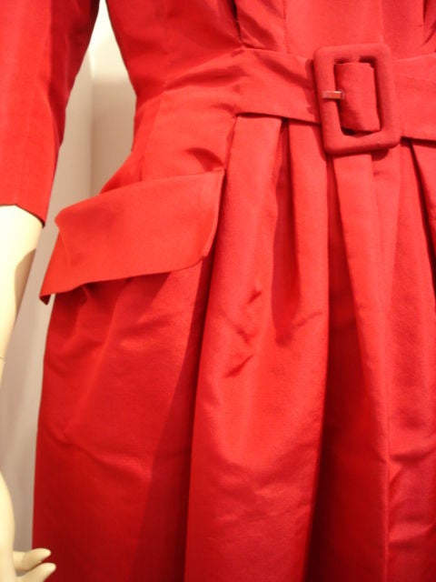 Dior red and silk faille new look with a belted waist, banded back, with stand away pockets and plunged neckline and 3/4 length sleeves.