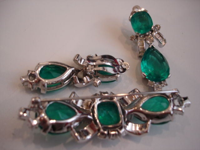 Incredibly realistic faux emerald brooch and earring set by Jomaz of New York.  Classic regal setting with clear rhinestones and emerald tone stones.<br />
<br />
Brooch: 3in. long, 3/4in wide