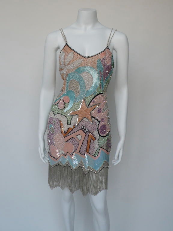 Stephen Sprouse design, manufactured during his graffiti period. The dress has sequins and glass beads throughout with a fringe of silver bugle beads. The spaghetti straps are lined with tiny faux pearls along the silk straps. There is not one bead