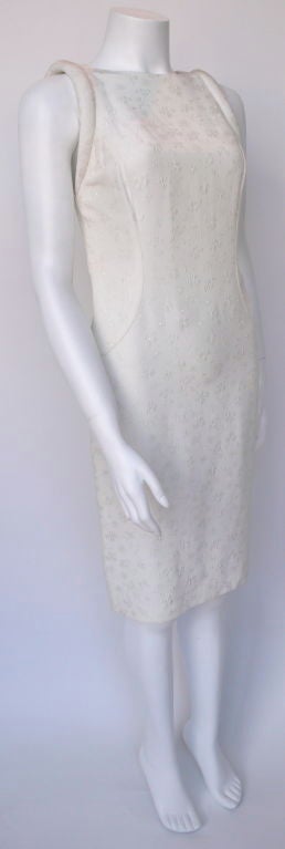 This off-white silk brocade dress falls at the knee. The shoulders are rolled and padded giving height adding shape to the silhouette. It can be worn day through night.