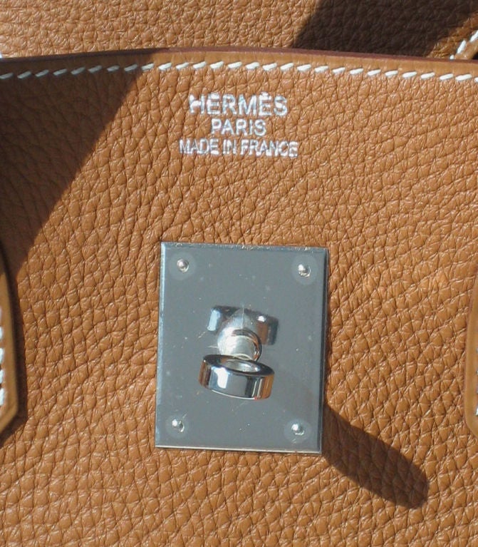 Hermès 35cm Birkin<br />
Gold Taurillon Clemence Leather<br />
Palladium Hardware | K Stamp<br />
<br />
Brand new, never carried, Hermès 35cm Birkin bag in gold taurillion clemence leather with shiny Palladium hardware.<br />
<br />
The